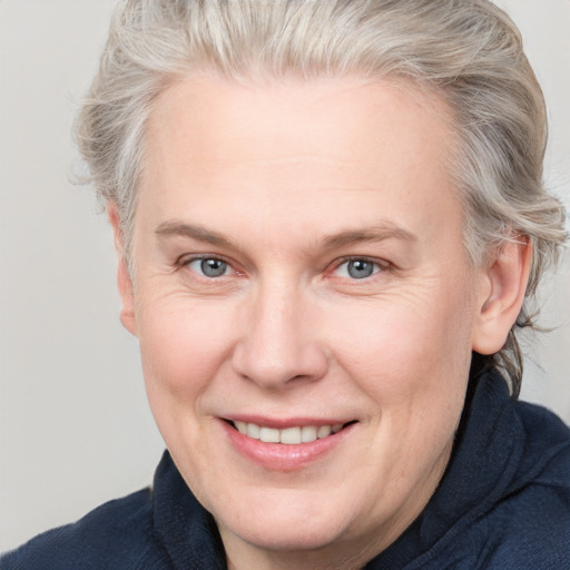 Joyful white adult female with medium  brown hair and blue eyes