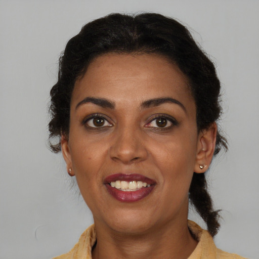 Joyful black adult female with medium  brown hair and brown eyes