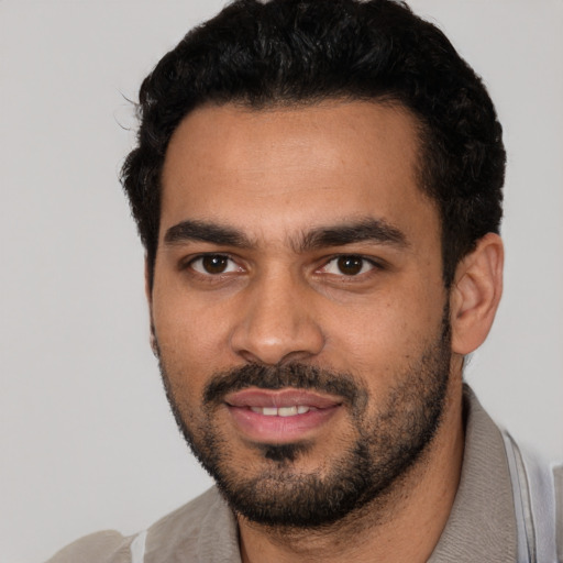 Joyful latino young-adult male with short  black hair and brown eyes