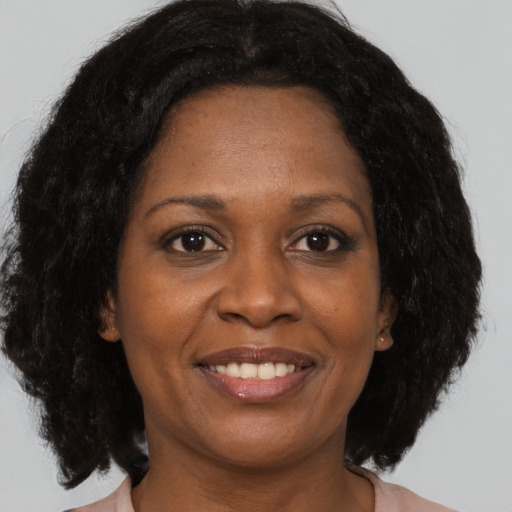 Joyful black adult female with medium  brown hair and brown eyes
