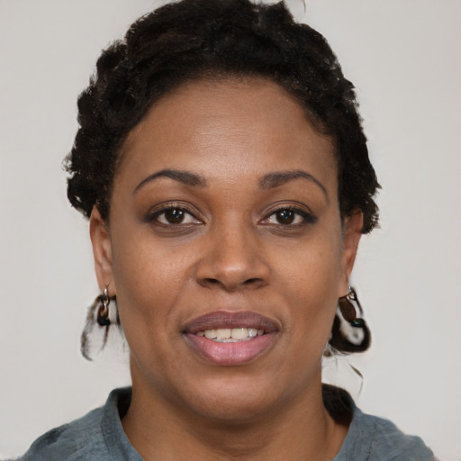Joyful black adult female with short  brown hair and brown eyes