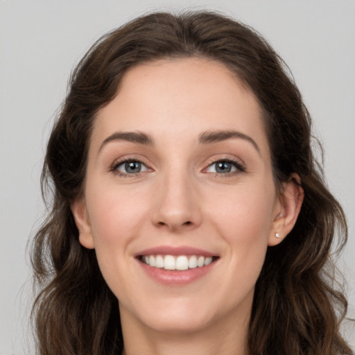 Joyful white young-adult female with long  brown hair and grey eyes