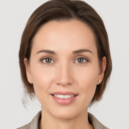 Joyful white young-adult female with medium  brown hair and grey eyes