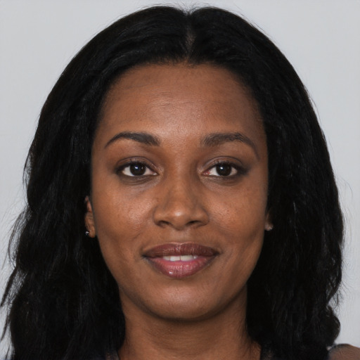 Joyful black young-adult female with long  black hair and brown eyes