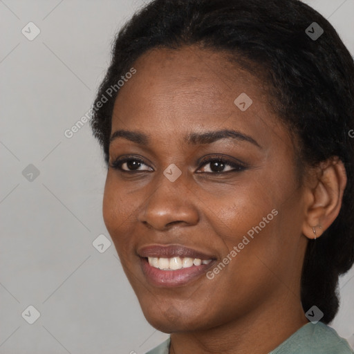 Joyful black young-adult female with short  black hair and brown eyes