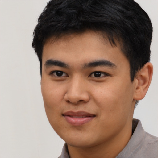 Joyful asian young-adult male with short  black hair and brown eyes