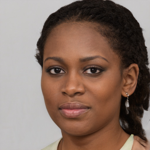 Joyful black young-adult female with long  brown hair and brown eyes