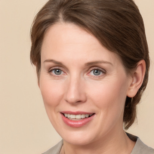 Joyful white adult female with medium  brown hair and grey eyes