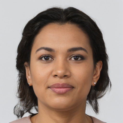 Joyful latino young-adult female with medium  brown hair and brown eyes