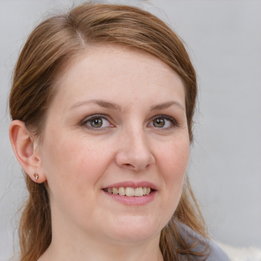 Joyful white young-adult female with long  brown hair and blue eyes