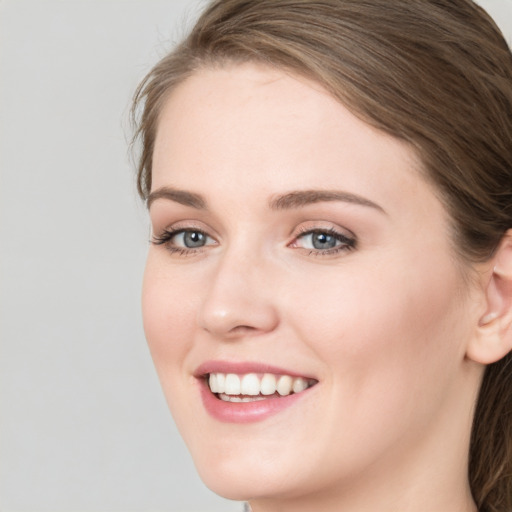 Joyful white young-adult female with long  brown hair and blue eyes