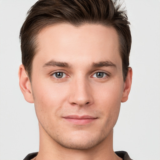 Joyful white young-adult male with short  brown hair and grey eyes