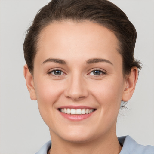 Joyful white young-adult female with short  brown hair and grey eyes