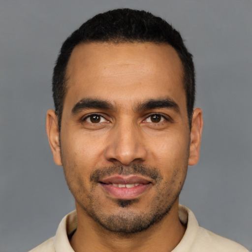 Joyful latino young-adult male with short  black hair and brown eyes