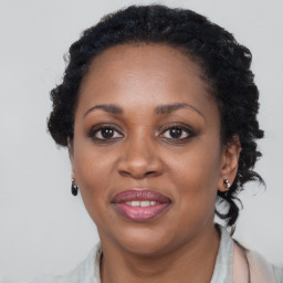 Joyful black adult female with long  black hair and brown eyes