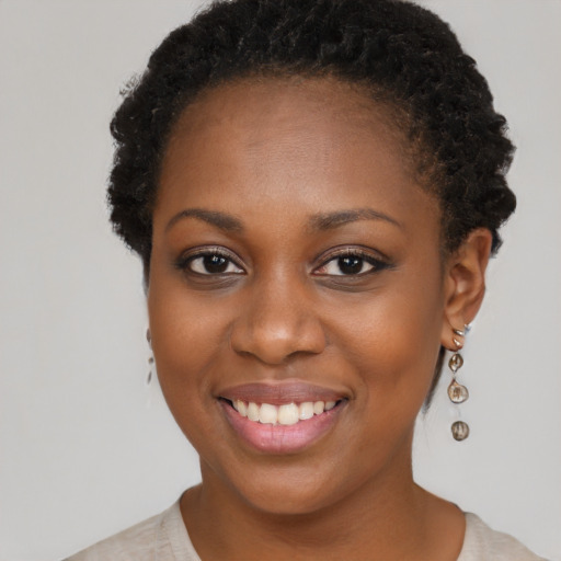 Joyful black young-adult female with short  black hair and brown eyes