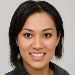 Joyful latino young-adult female with medium  brown hair and brown eyes