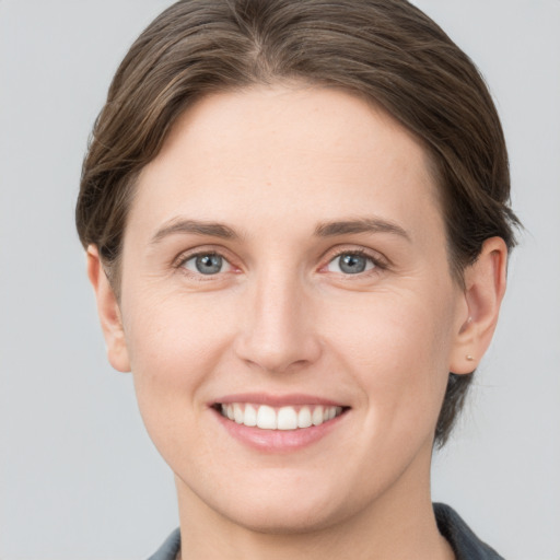 Joyful white young-adult female with short  brown hair and grey eyes