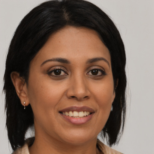 Joyful latino adult female with medium  brown hair and brown eyes