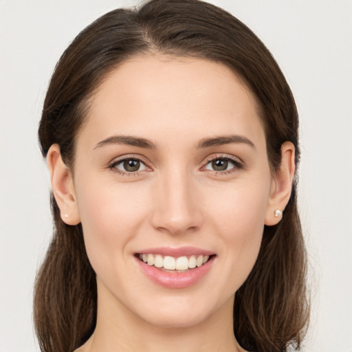 Joyful white young-adult female with long  brown hair and brown eyes