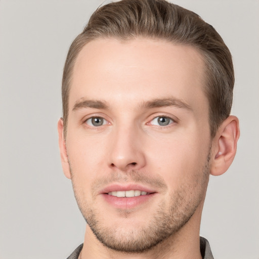 Joyful white young-adult male with short  brown hair and grey eyes