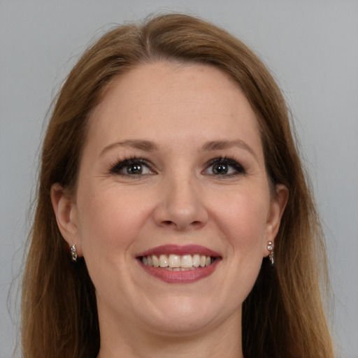 Joyful white adult female with long  brown hair and grey eyes