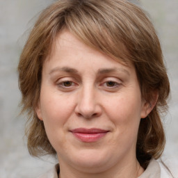 Joyful white adult female with medium  brown hair and grey eyes