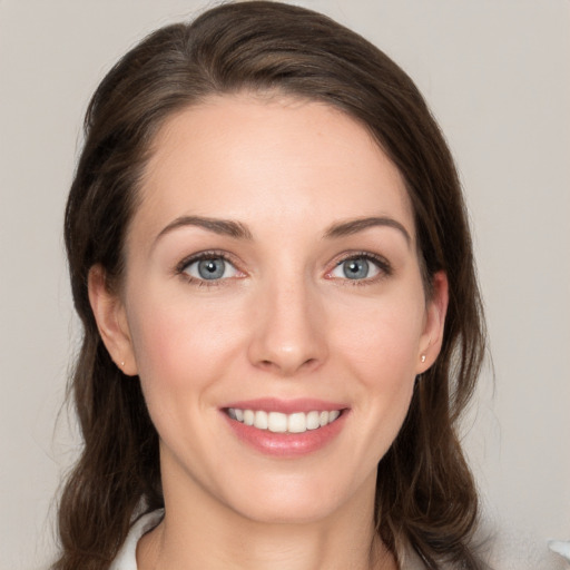 Joyful white young-adult female with medium  brown hair and grey eyes