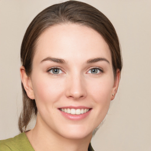 Joyful white young-adult female with medium  brown hair and green eyes