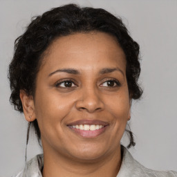 Joyful black adult female with medium  brown hair and brown eyes