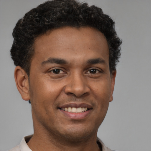 Joyful latino young-adult male with short  brown hair and brown eyes