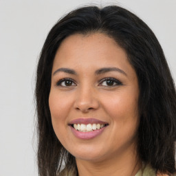 Joyful latino young-adult female with long  brown hair and brown eyes