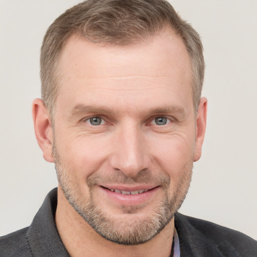 Joyful white adult male with short  brown hair and grey eyes