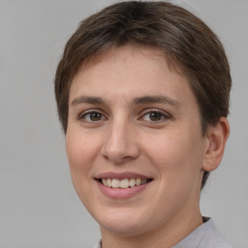 Joyful white young-adult female with short  brown hair and grey eyes