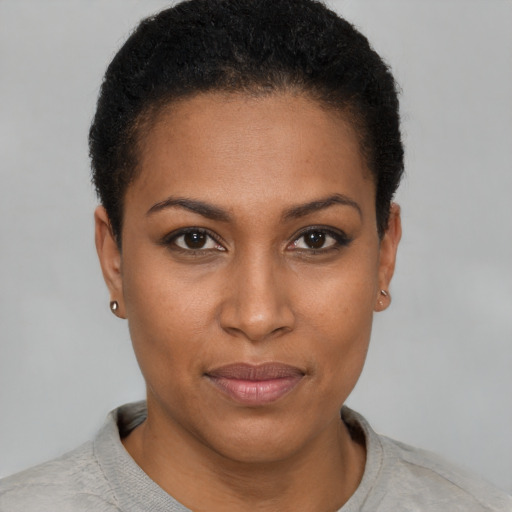 Joyful black young-adult female with short  black hair and brown eyes