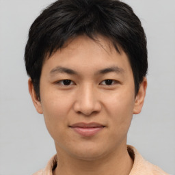 Joyful asian young-adult male with short  brown hair and brown eyes