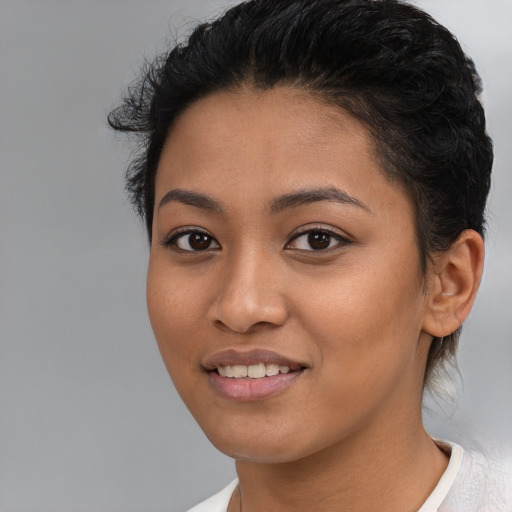 Joyful latino young-adult female with short  black hair and brown eyes