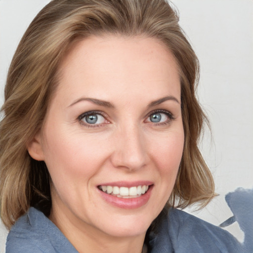 Joyful white young-adult female with long  brown hair and blue eyes