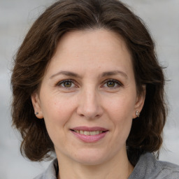 Joyful white adult female with medium  brown hair and grey eyes