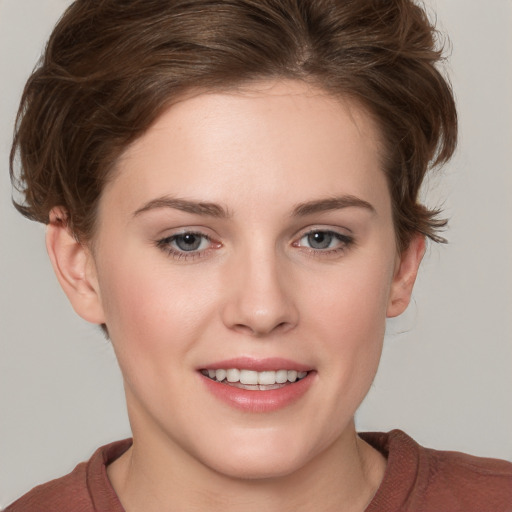 Joyful white young-adult female with short  brown hair and blue eyes