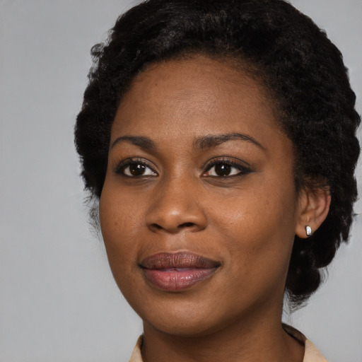 Joyful black young-adult female with long  brown hair and brown eyes