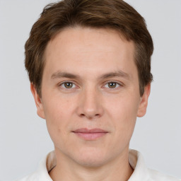 Joyful white young-adult male with short  brown hair and grey eyes