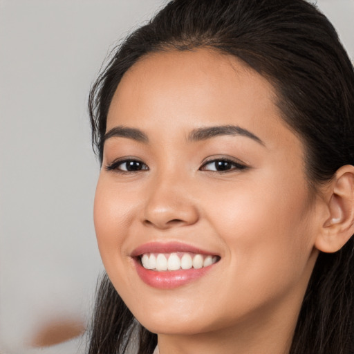 Joyful white young-adult female with long  brown hair and brown eyes