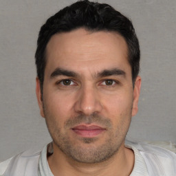Joyful white young-adult male with short  black hair and brown eyes