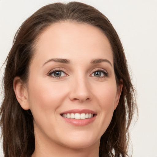 Joyful white young-adult female with long  brown hair and grey eyes