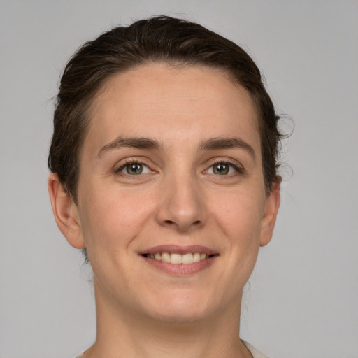 Joyful white young-adult female with short  brown hair and grey eyes