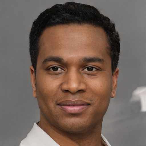Joyful black young-adult male with short  black hair and brown eyes