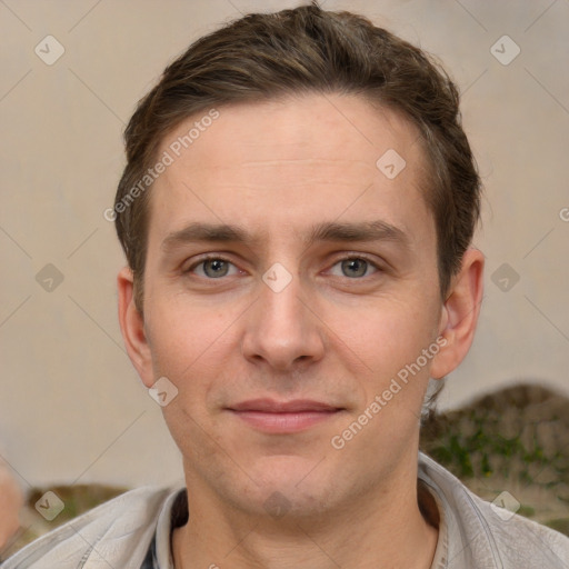 Joyful white young-adult male with short  brown hair and grey eyes