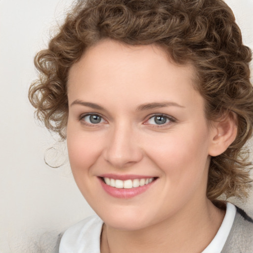 Joyful white young-adult female with medium  brown hair and blue eyes