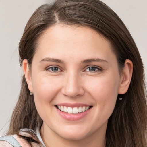 Joyful white young-adult female with long  brown hair and grey eyes